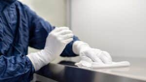 An employee with white globes working in a wet plant cleaning facility