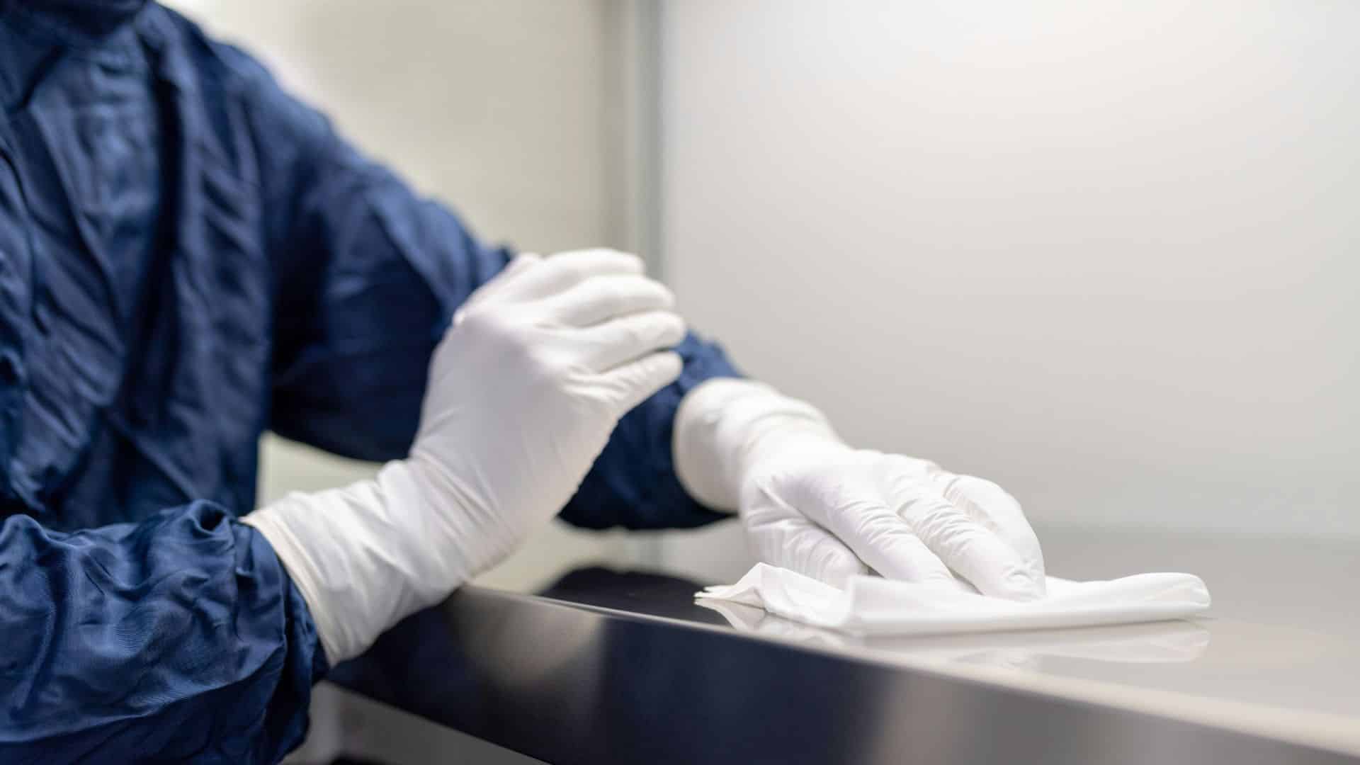 An employee with white globes working in a wet plant cleaning facility
