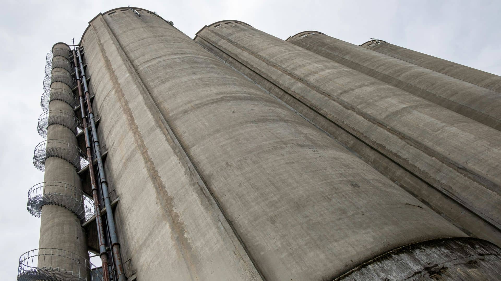 A low‐angle view of tall, cylindrical food storage silos, ready for dry plant cleaning.