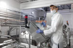 Staff member conducting a food safety audit of a dairy factory.